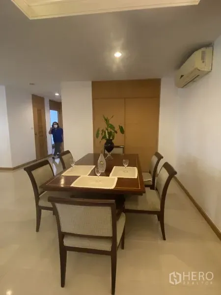 Condominium for rent - Dining area with wooden table set, placemats, split air conditioner and recessed lighting in a neutral-toned condo.