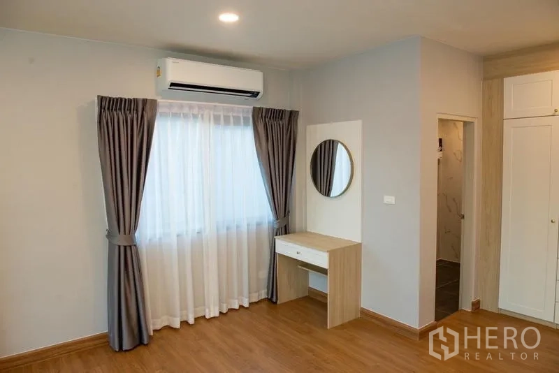 Detached House for rent in Bang Phli, Samut Prakan - Bedroom corner with dressing table, air conditioning and window drapes.