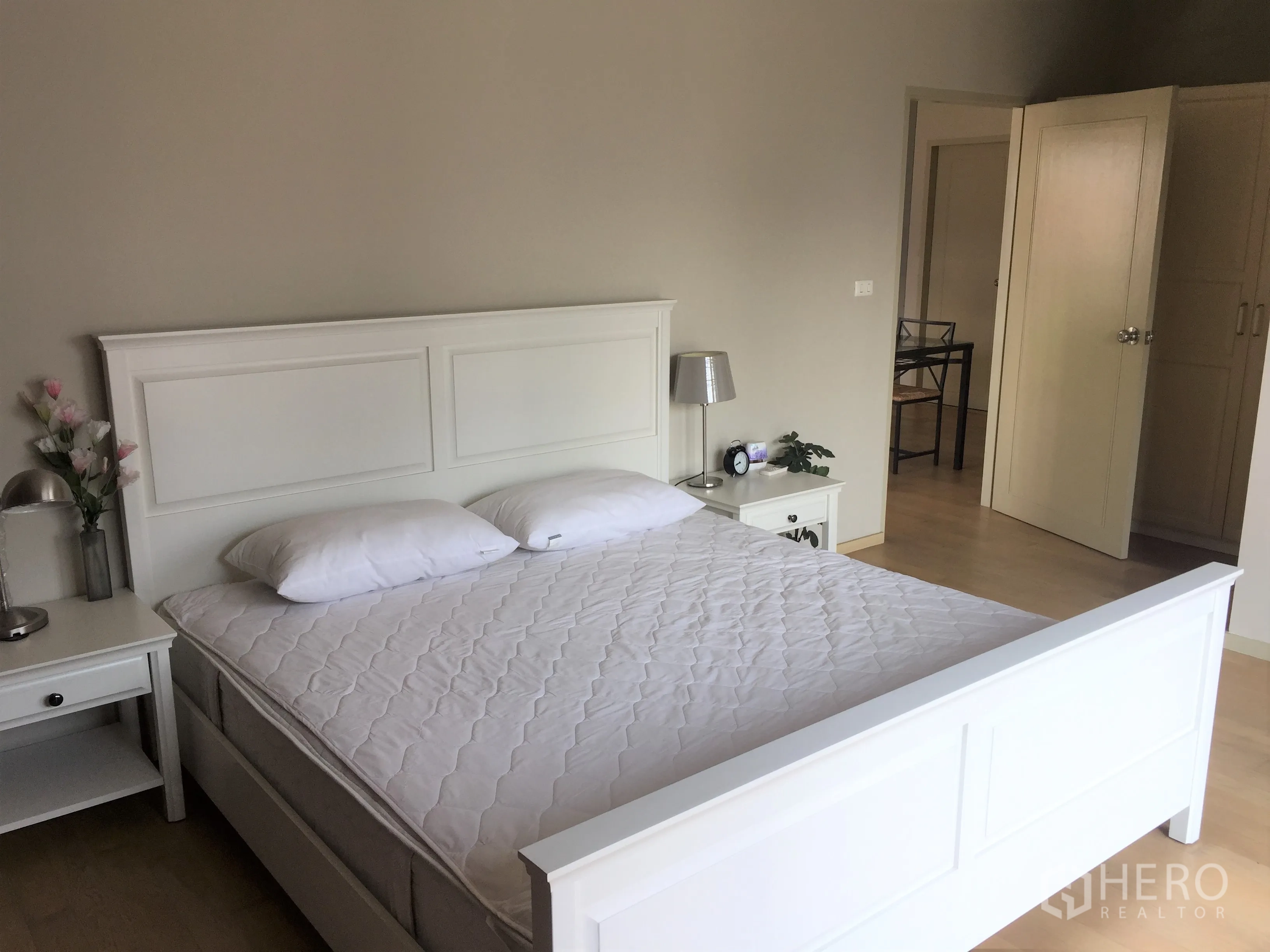 คอนโด ให้เช่าหรือขายในWatthana, Bangkok - ห้องนอนหลักกว้าง เตียงสีขาว โต๊ะข้างเตียง และพื้นไม้