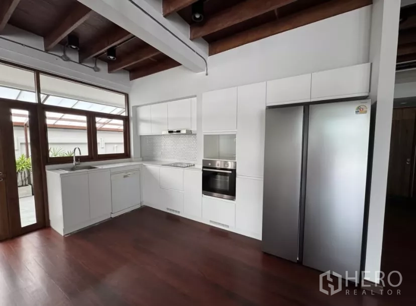 独立式住宅 出租在Watthana, Bangkok - 亮白轻型厨房，内置烤箱与对开门冰箱。