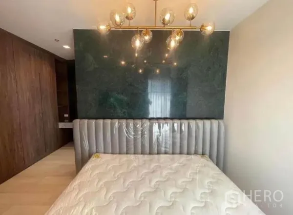 Condominium for rent or sale - Bedroom with upholstered headboard, chandelier and built-in wardrobe.