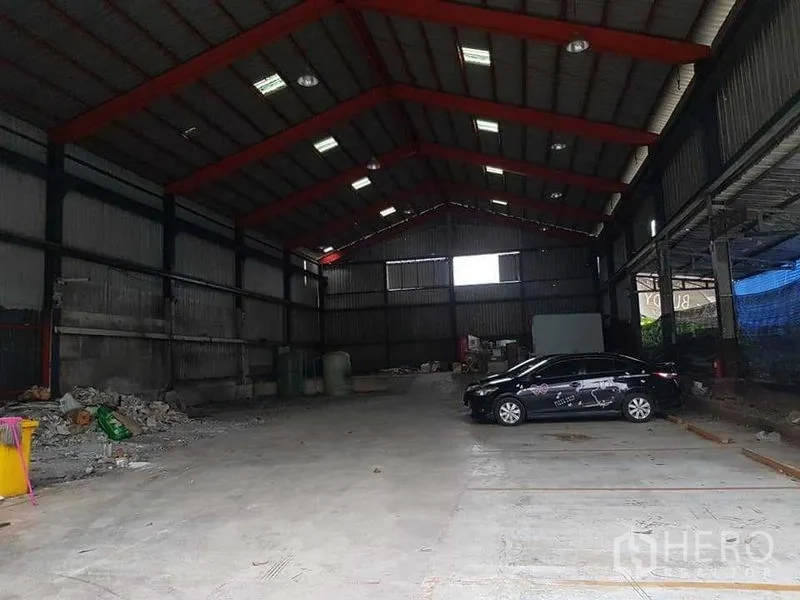 คลังสินค้า ให้เช่าในThung Khru, Bangkok - พื้นโกดังช่วงกว้างโล่ง มีรถเก๋งจอดและผนังเมทัลชีทลูกฟูก