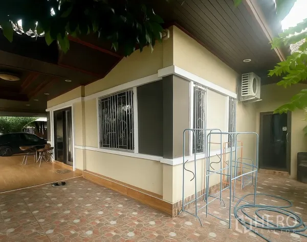 独立式住宅 出售在Pathum Thani - 房侧露台，推拉门与带护栏窗户，外挂机空调。