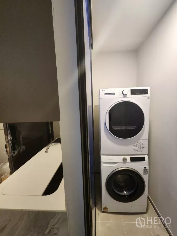 Townhouse for rent in Khlong Toei, Bangkok - In‑unit stacked washer and dryer in a utility alcove.
