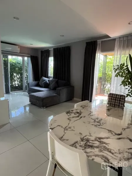 Detached House for rent in Suan Luang, Bangkok - Open-plan living and dining area with a marble-top table and garden views