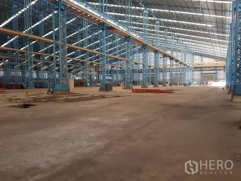 โรงงาน ให้เช่าในMueang Samut Sakhon, Samut Sakhon - ฮอลล์โรงงานเพดานสูง โครงสร้างเหล็ก เสาสีน้ำเงิน มีสกายไลต์และคานรางเครน
