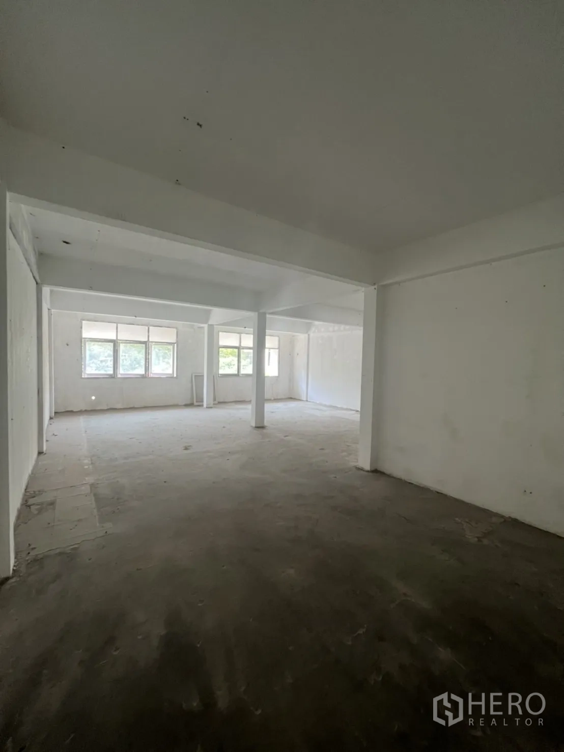 店屋 出租在Watthana, Bangkok - 宽敞空置楼层，大窗与水泥地面。