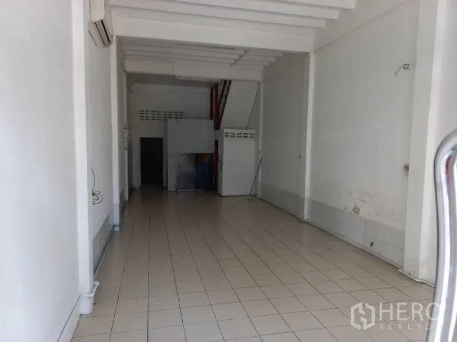 อาคารพาณิชย์ ให้เช่าในKhlong Toei, Bangkok - ชั้นล่างพื้นที่เปิดโล่งของอาคารพาณิชย์ ผนังสีขาว พื้นกระเบื้อง คานเพดานสูง และโซนบริการด้านหลังพร้อมประตูห้องน้ำ