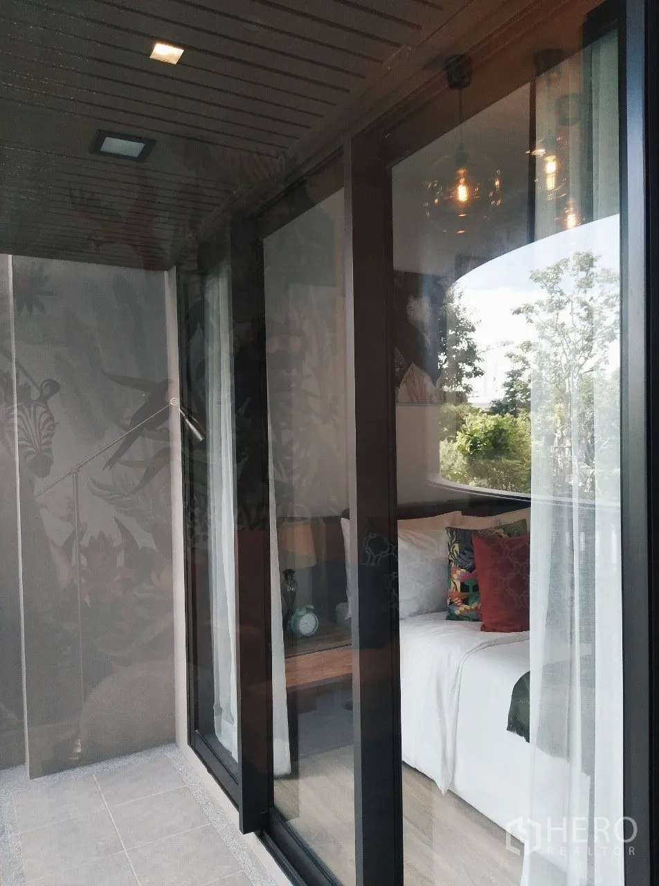 公寓 for rent in Watthana, Bangkok - 卧室推拉玻璃门通往阳台，可见绿树景观。