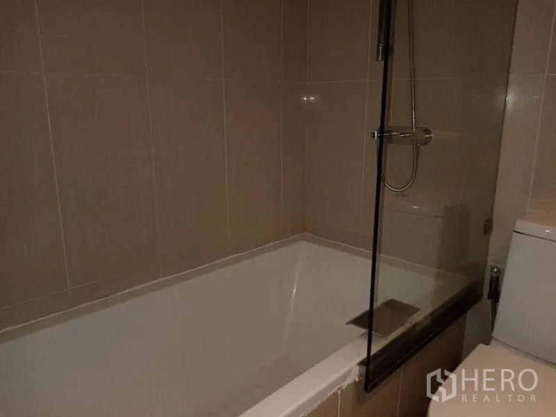 公寓 出租在Sathon, Bangkok - 浴室设深浸式浴缸，手持花洒与玻璃隔断。
