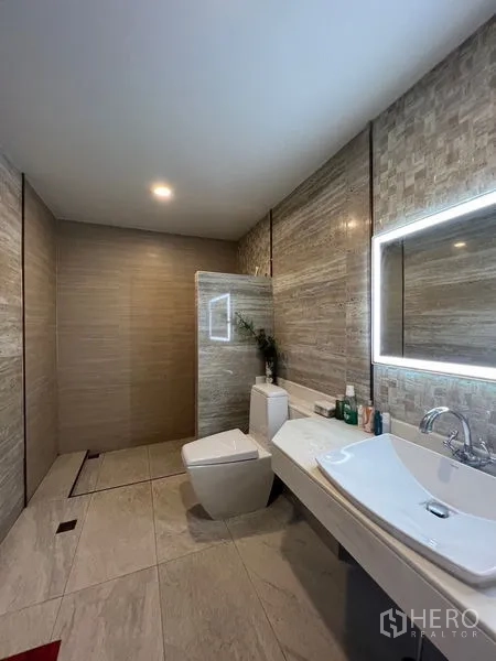 独立式住宅 出售在Chatuchak, Bangkok - 宽敞瓷砖卫浴，设大台盆、发光镜与壁挂式马桶，带步入式淋浴区。