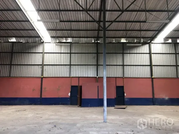 货栈 出租在Lam Luk Ka, Pathum Thani - 仓库内部，高挑钢结构屋顶、波纹金属墙面、混凝土地面与服务门。