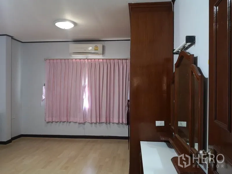 独立式住宅 出售 - 卧室配粉色窗帘、空调与木质梳妆台。