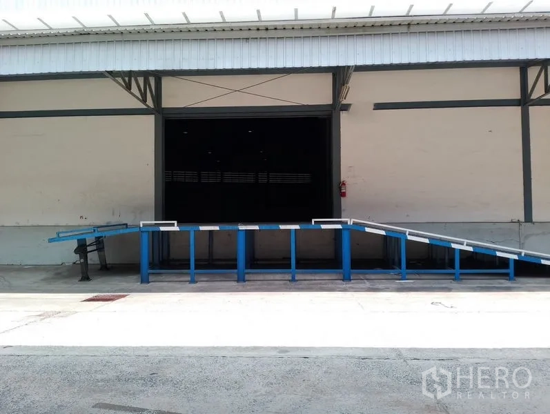货栈 出租在Bang Phli, Samut Prakan - 近景展示蓝色登车桥与卷帘门，位于带棚装卸口。