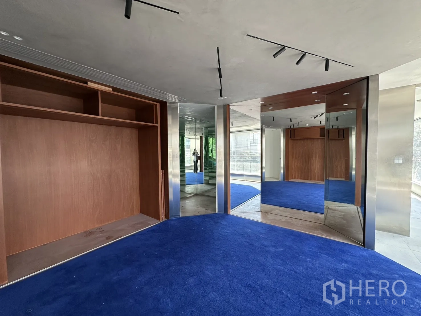 Retail Space for rent in Watthana, Bangkok - Showroom corner featuring mirrors, wood cabinetry, and blue carpeted flooring.