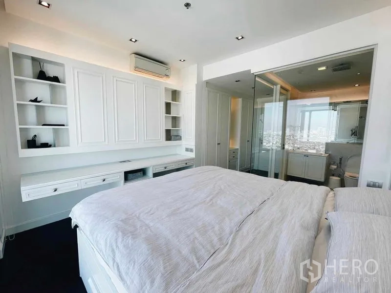 Condominium for rent or sale in Bang Kho Laem, Bangkok - Primary bedroom with built-in cabinetry and a glass-partitioned en-suite bathroom.