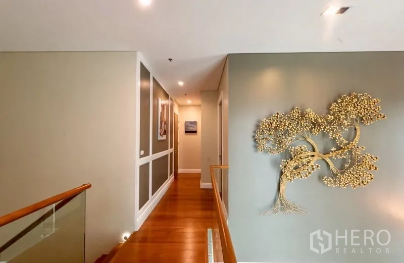 คอนโด ให้เช่าในKhlong Toei, Bangkok - ทางเดินชั้นบนพื้นไม้พร้อมงานศิลป์รูปต้นไม้บนผนัง