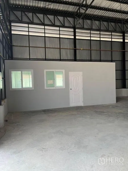 Warehouse for rent in Nonthaburi - Internal view of the office block with windows inside the warehouse space.