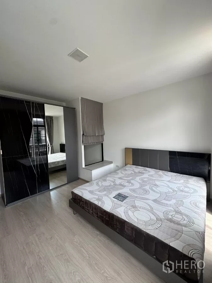 Townhouse for rent in Bang Phli, Samut Prakan - Spacious master bedroom with king bed and mirrored sliding wardrobe.