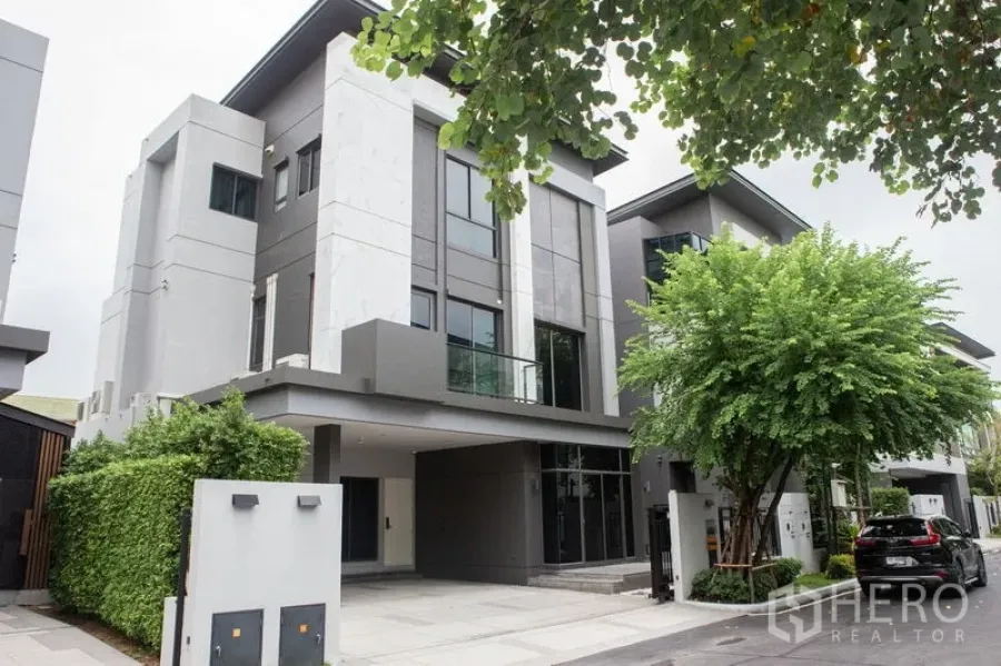 独立式住宅 出租或出售在Bangkok - 正立面视角的三层独栋，带车道与绿篱。