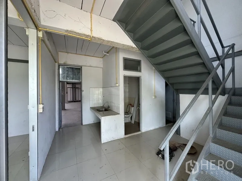 工厂 出租在Lam Luk Ka, Pathum Thani - 一层杂物区，设水槽、卫生间及金属楼梯。