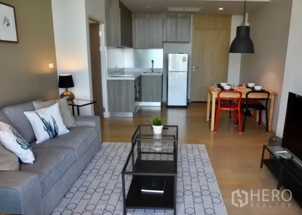 คอนโด ให้เช่าในPhaya Thai, Bangkok - โถงนั่งเล่นแบบโอเพนแพลนพร้อมครัวบิวท์อิน ตู้เย็น และชุดโต๊ะทานอาหาร พื้นไม้โทนอ่อน.