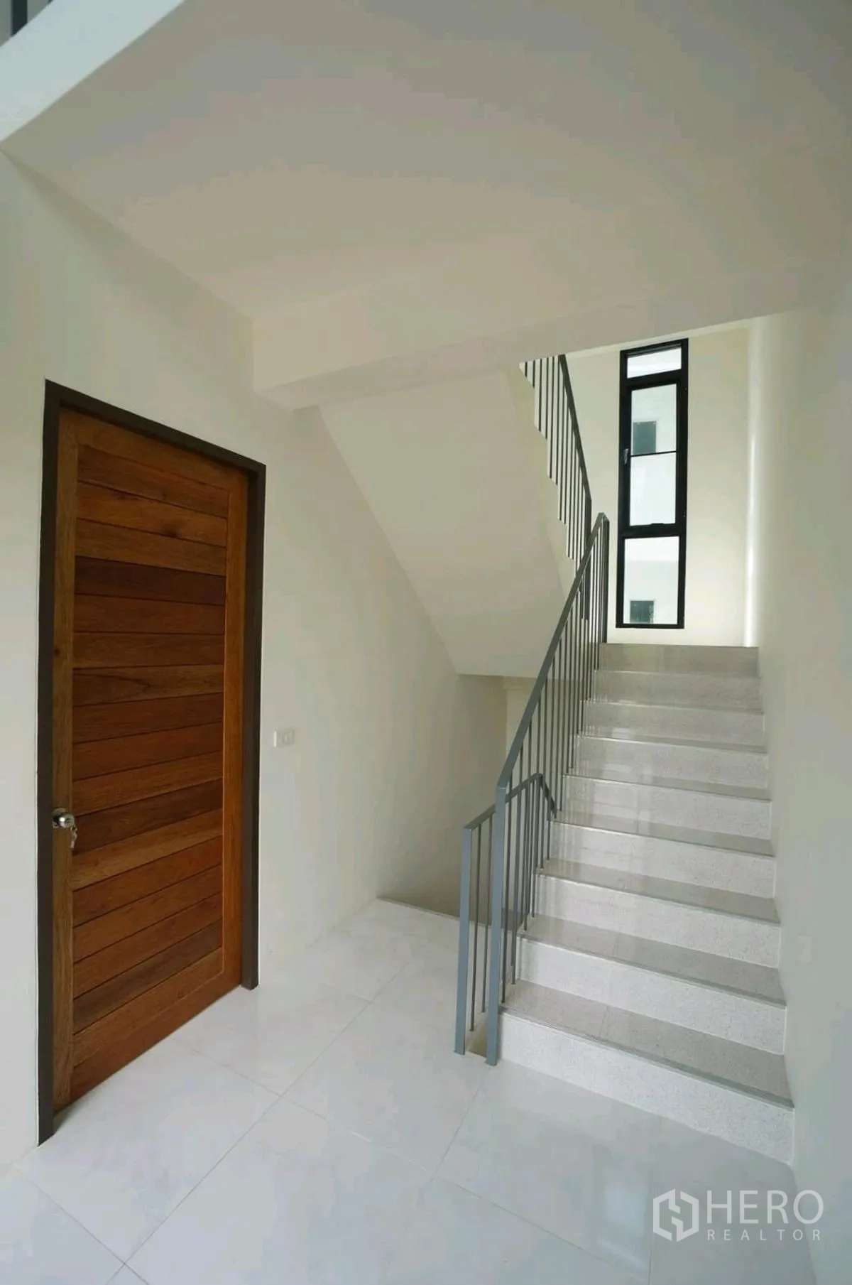 家庭办公室 for rent in Chatuchak, Bangkok - 楼梯平台旁设木门与高挑窄窗。