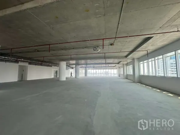 Office Space for rent in Sathon, Bangkok - Large shell office floor in Sathon Bangkok with exposed ceiling, red fire-sprinkler lines and long rows of windows.