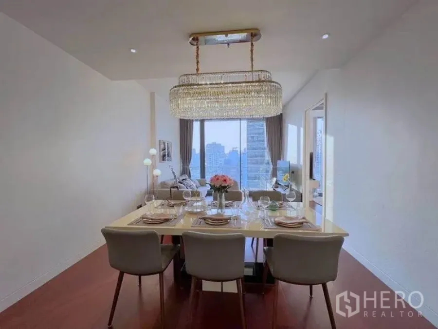 公寓 出租在Watthana, Bangkok - 正式餐区，水晶吊灯对向客厅与整面落地窗。