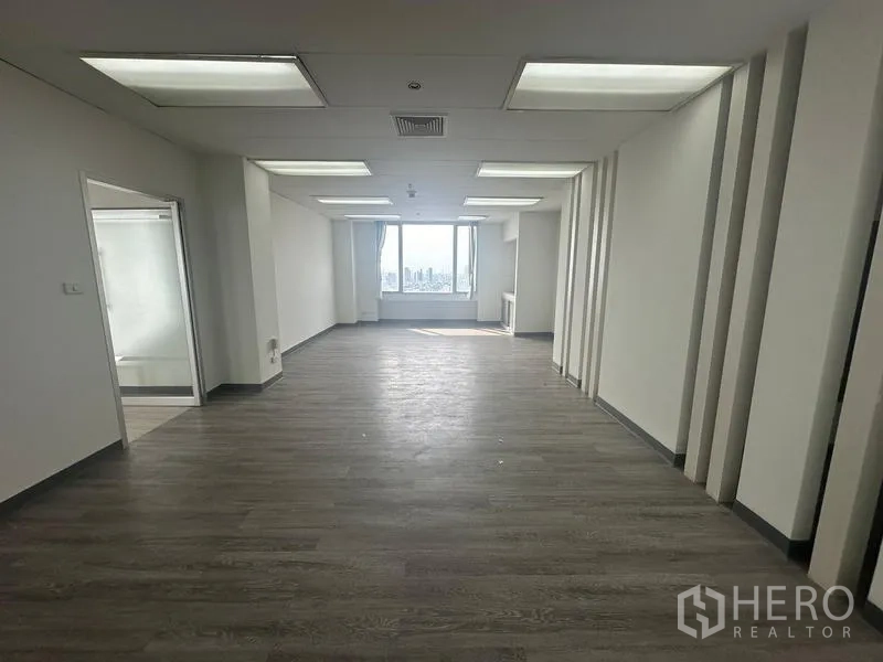 สำนักงาน ให้เช่า - โซนออฟฟิศทรงสี่เหลี่ยมผืนผ้า พื้นโทนเข้มและหน้าต่างปลายห้องรับแสง