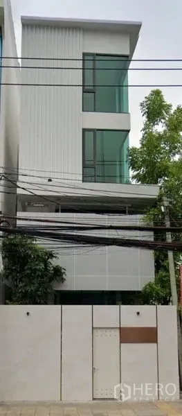 Home Office for rent in Suan Luang, Bangkok - Street view of the sleek multi-level home office exterior behind a high gate.