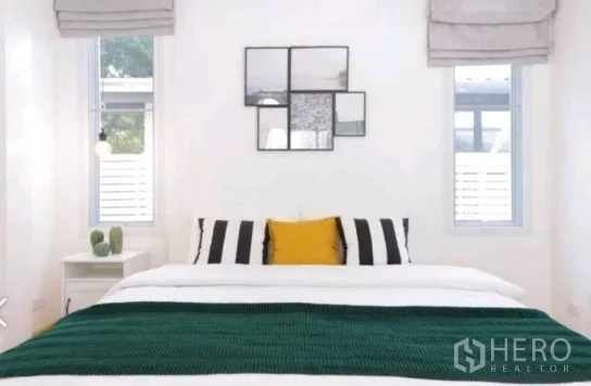 ทาวน์เฮาส์ ให้เช่าในKhlong Toei, Bangkok - ห้องนอนมินิมอล ผนังขาว กรอบรูป เหนือเตียงมีหน้าต่างแคบสองบาน