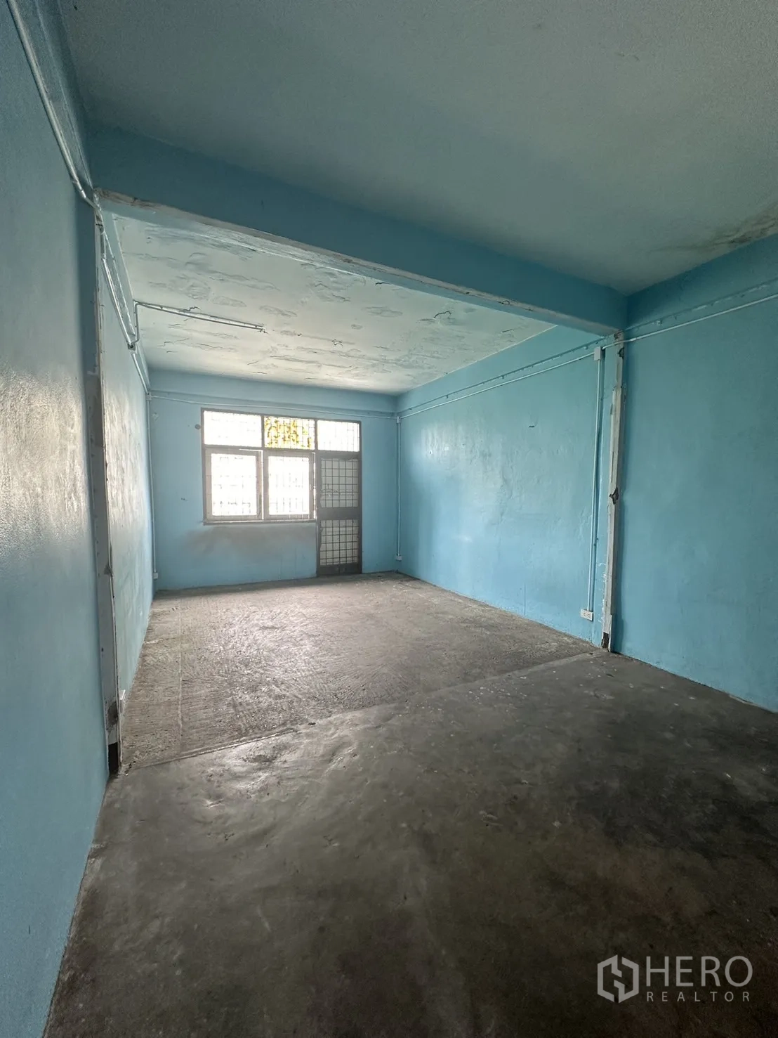 店屋 出租在Watthana, Bangkok - 空置蓝色房间，水泥地面并有后窗采光。