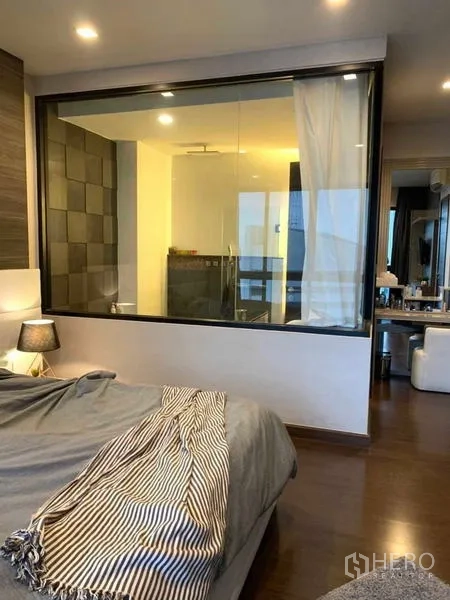 Condominium for rent or sale in Huai Khwang, Bangkok - Bedroom with interior glass wall facing the ensuite bath and study nook.