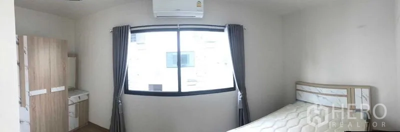 联排别墅 出租或出售在Prawet, Bangkok - 配家具的卧室，含床、衣柜、梳妆台与大窗户及空调。