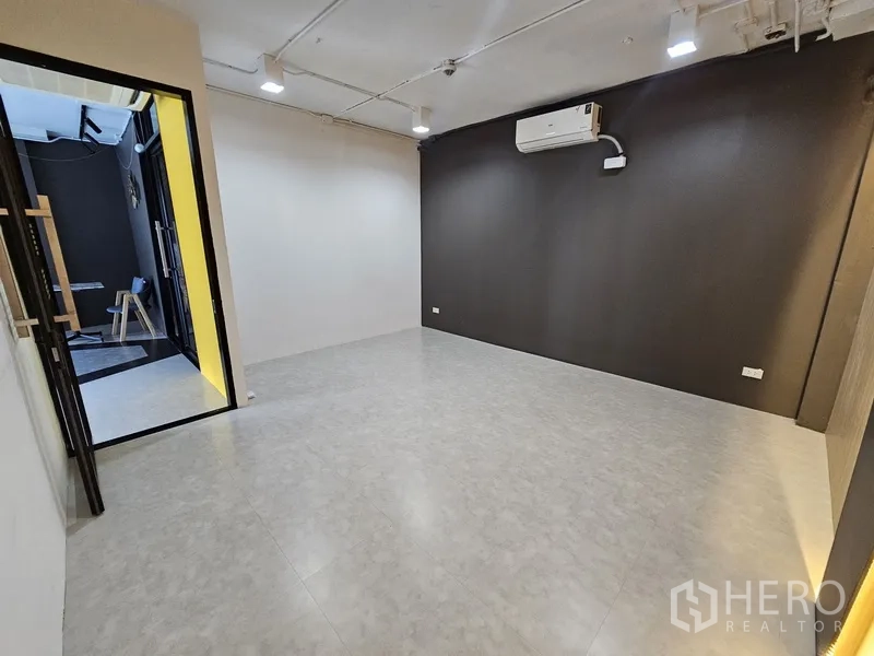 零售空间 出租 - 独立房间，配分体空调，黑白对比墙面与瓷砖地面。