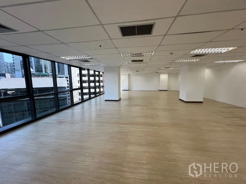 办公空间 出租 - 开放办公区，一整面窗俯瞰曼谷天际线，中央空调出风口可见。