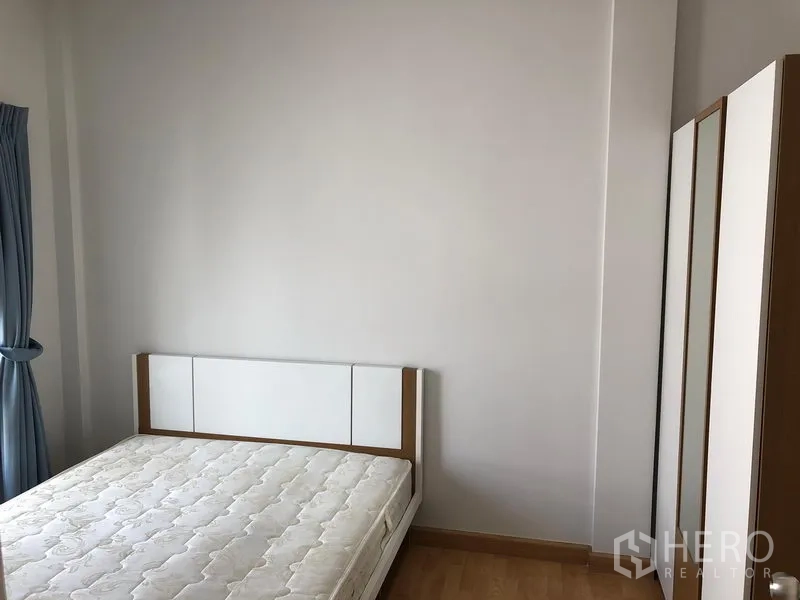 联排别墅 出租或出售在Wang Thonglang, Bangkok - 简约卧室，配床架、床垫、衣柜与蓝色窗帘。