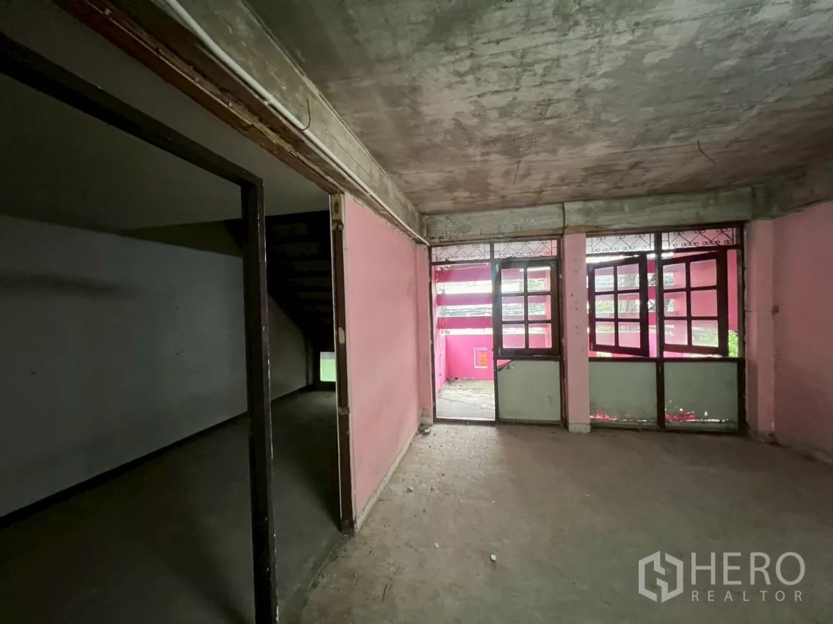 店屋 出租在Watthana, Bangkok - 粉色开间通阳台，旁有较暗的相邻房间。