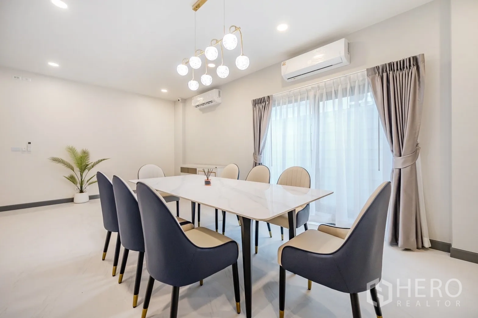 Detached House for rent in Bang Phli, Samut Prakan - Dining space with marble-top table, air-conditioning and sheer drapes