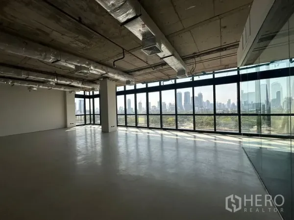 Office Space for rent in Watthana, Bangkok - Open workspace with full-height glazing, industrial ceiling, glass partition and wide city and park vistas.