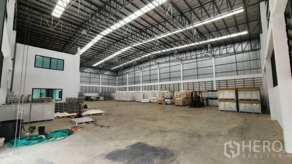 货栈 出租在Ban Phaeo, Samut Sakhon - 高挑仓库内部，钢结构屋架与采光带，旁接两层办公楼。