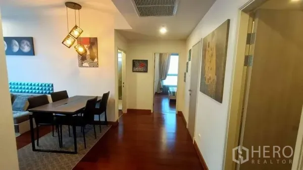 คอนโด ขาย - โถงและมุมทานอาหาร พื้นไม้ โคมไฟห้อย และงานศิลปะ มองไปยังห้องนอน