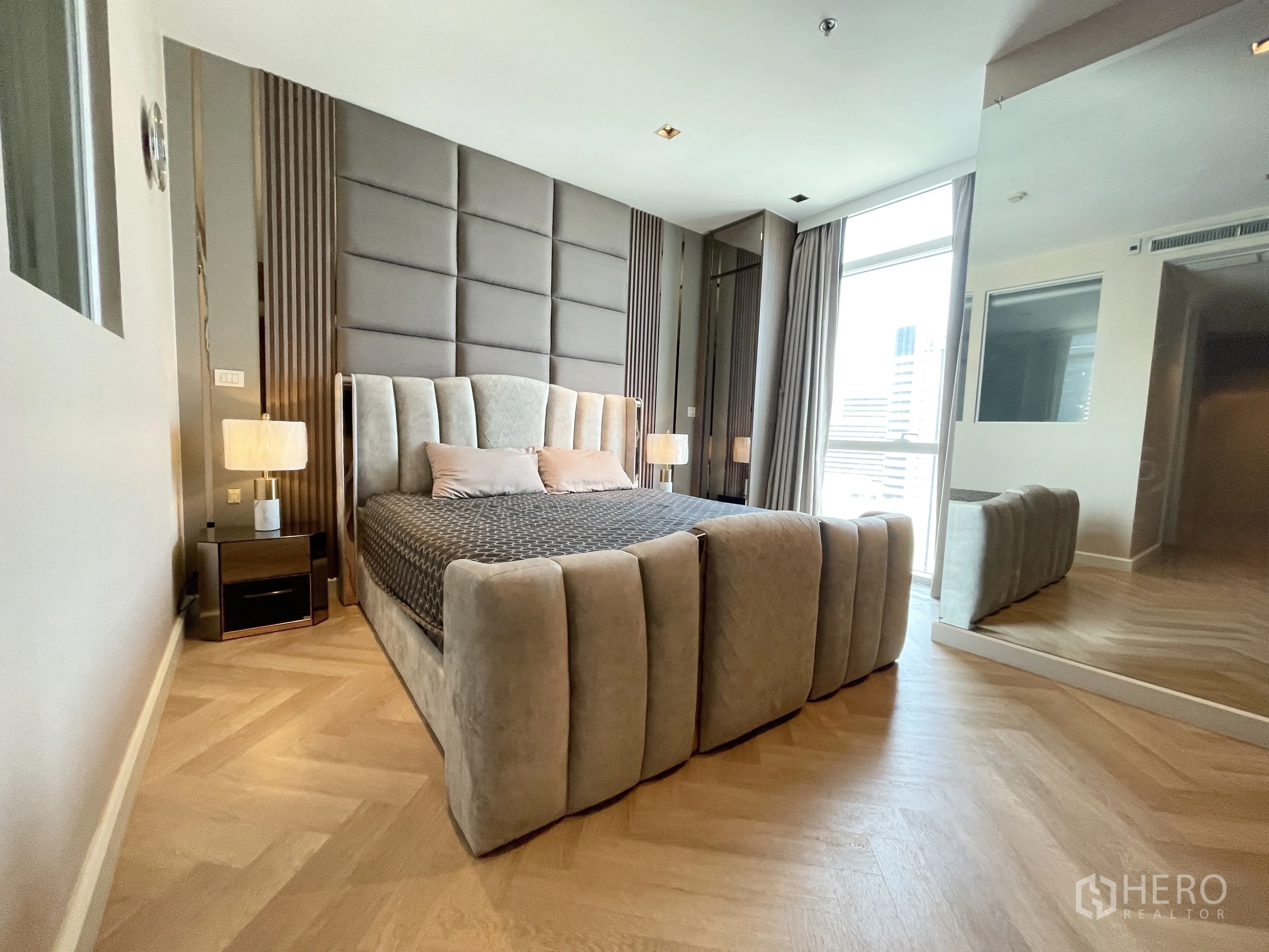 คอนโด for rent in Pathum Wan, Bangkok - ห้องนอนมาสเตอร์กว้างขวาง เตียงหัวบุผ้า โคมไฟข้างเตียง และหน้าต่างบานใหญ่