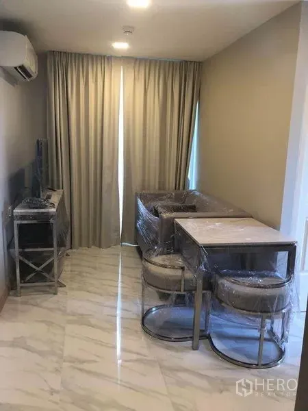 Condominium for  in Watthana, Bangkok - Another angle of the living-dining room showing sofa, table, TV stand, split AC and blackout drapes.