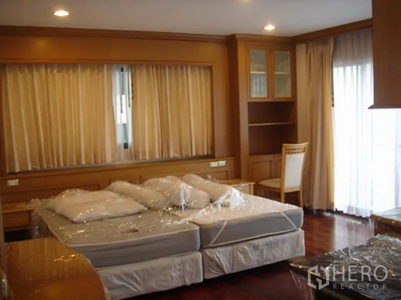 อพาร์ทเมนท์ ให้เช่าในKhlong Toei, Bangkok - ห้องนอนใหญ่ เตียงขนาดใหญ่ ตู้บิวท์อิน และประตูกระจกเปิดสู่ระเบียง