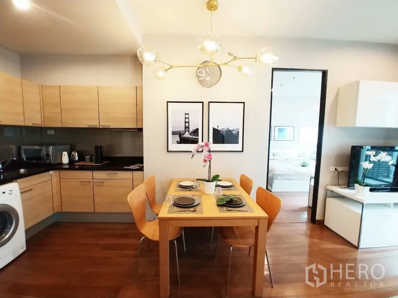 คอนโด ให้เช่าในPathum Wan, Bangkok - ครัวแบบเปิด ตู้ลายไม้ ชุดโต๊ะทานข้าว 4 ที่ โคมไฟโมเดิร์น พร้อมเครื่องซักผ้า