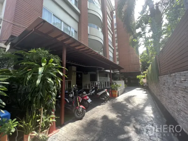 พื้นที่ขายปลีก ให้เช่าในKhlong Toei, Bangkok - ด้านนอกอาคารมีชานพักมุงหลังคา กระถางต้นไม้ และที่จอดมอเตอร์ไซค์