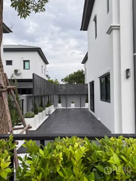 Detached House for rent in Bang Phli, Samut Prakan - Paved side yard with privacy screen, white pebble planters and low‑maintenance landscaping.