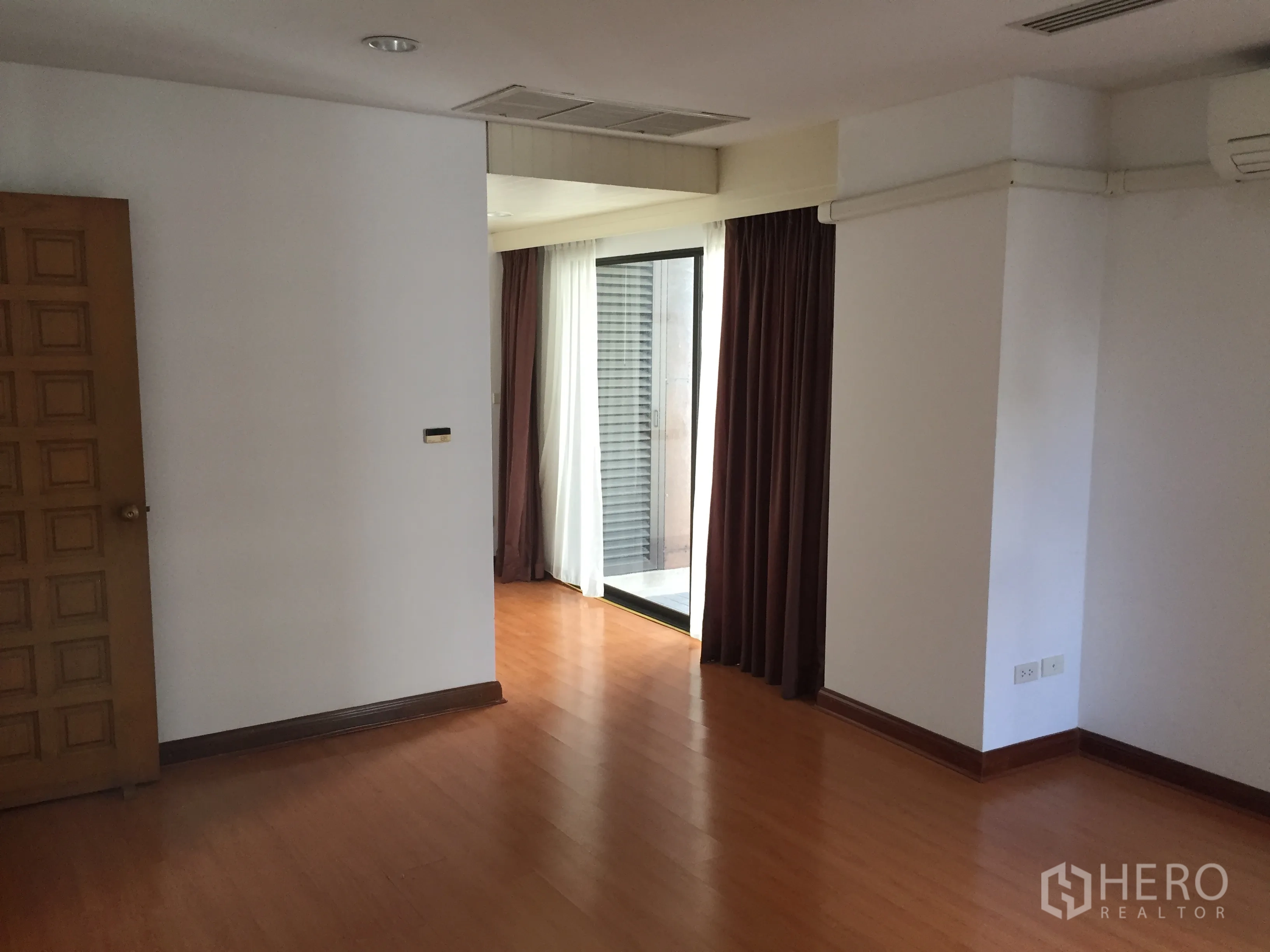 คอนโด ให้เช่าในPathum Wan, Bangkok - ห้องพื้นไม้ พร้อมเครื่องปรับอากาศ และประตูกระจกบานเลื่อนออกระเบียงพร้อมผ้าม่าน